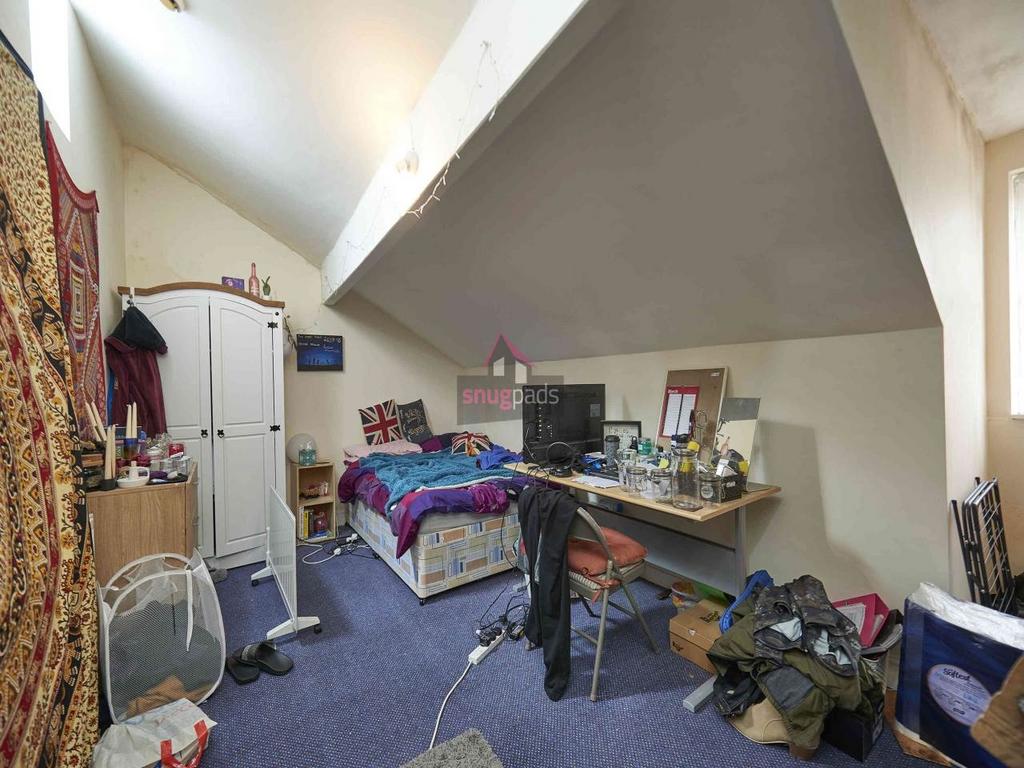 Cozy attic bedroom with sloped ceiling, fitted ...