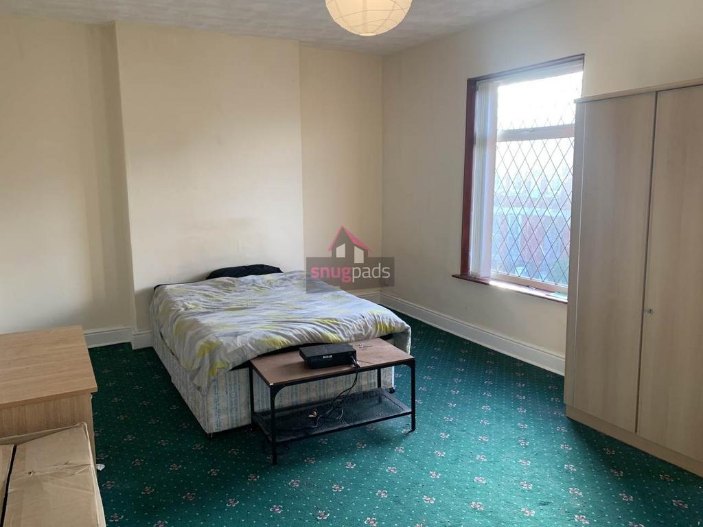 Bright, simply furnished bedroom with a double ...