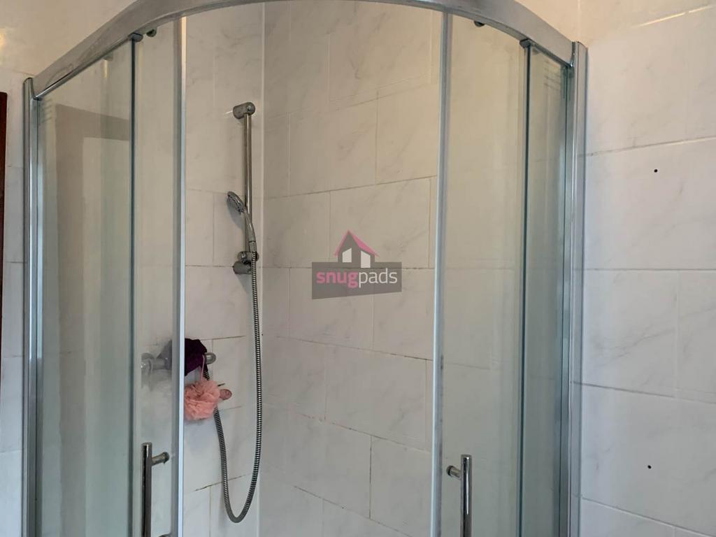 Bright modern bathroom with a curved glass show...