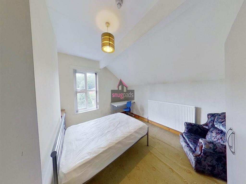 Bright single bedroom with a simple metal bed f...