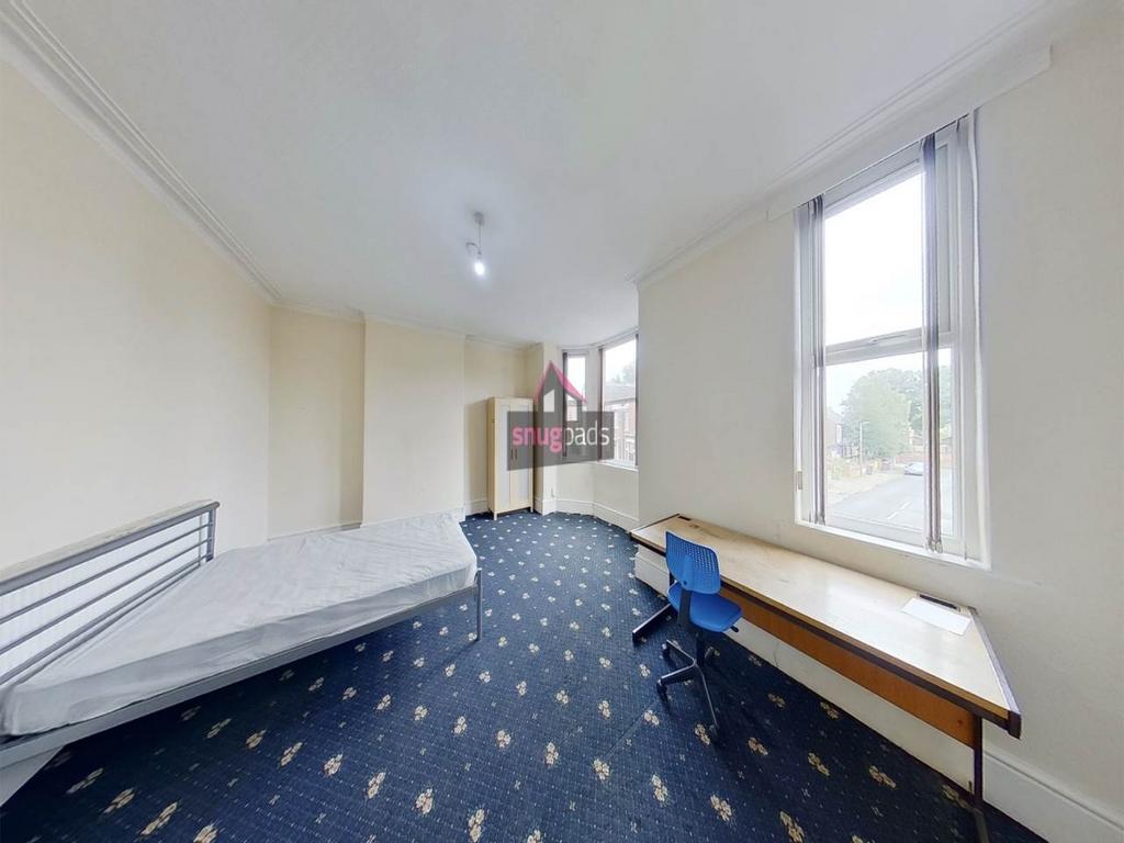 Bright, well-maintained bedroom with large wind...