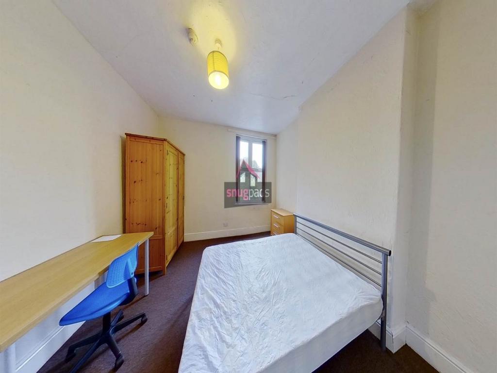 Bright, simply furnished bedroom with a double ...