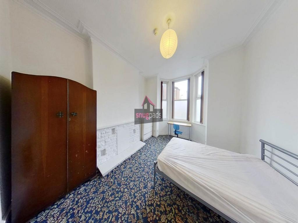 Bright, simply furnished bedroom with a large b...