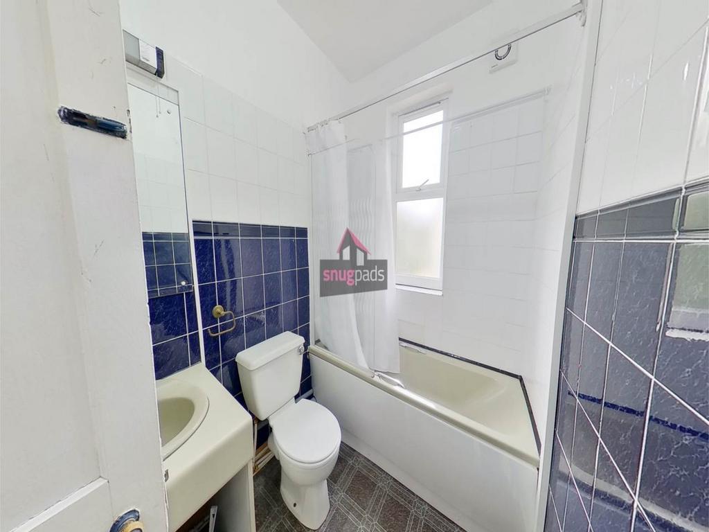 Bright, well-maintained bathroom with white san...