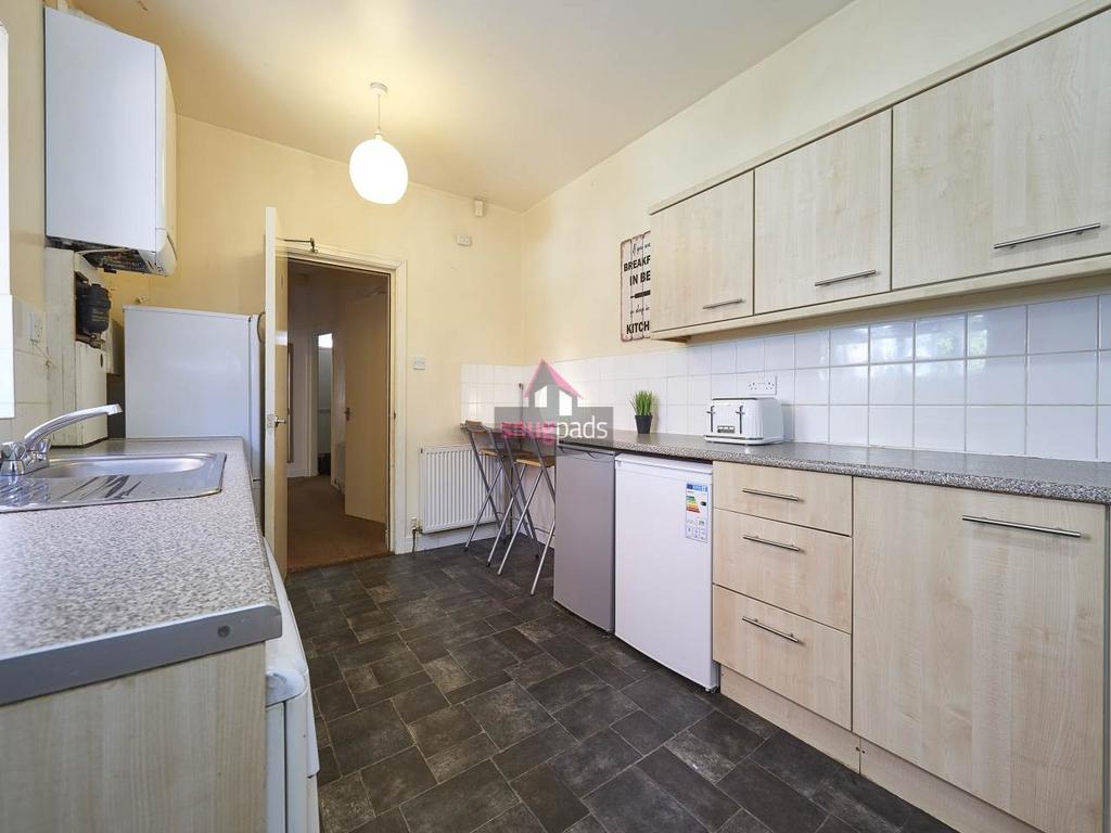 Bright, functional galley kitchen with light wo...