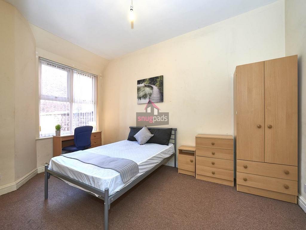 Bright, simply furnished bedroom with a single ...