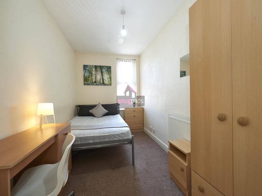Bright, simply furnished single bedroom with a ...