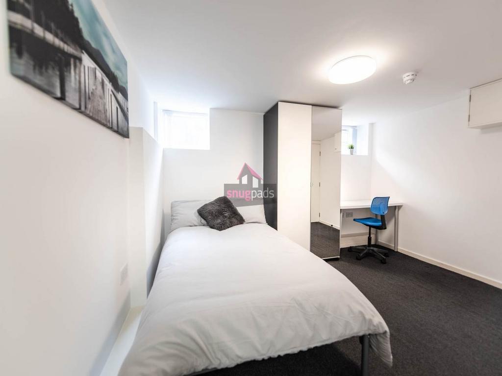 Bright, simply furnished bedroom with a comfort...