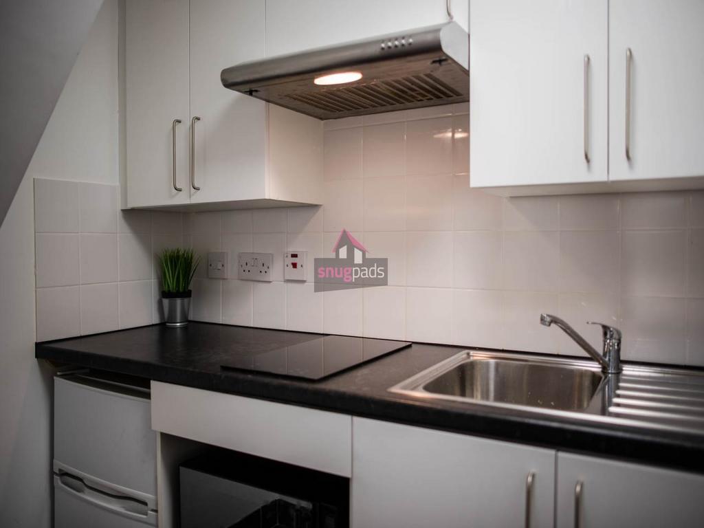 Modern compact kitchenette with sleek black wor...