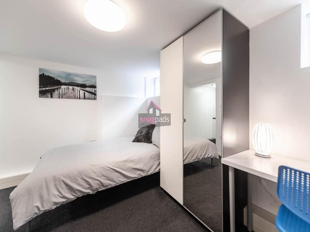 Bright, minimalist single bedroom with a neatly...