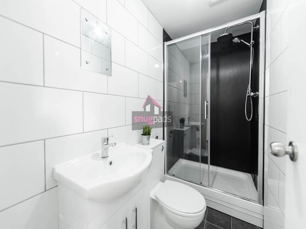 Bright, modern bathroom with a walk-in glass sh...