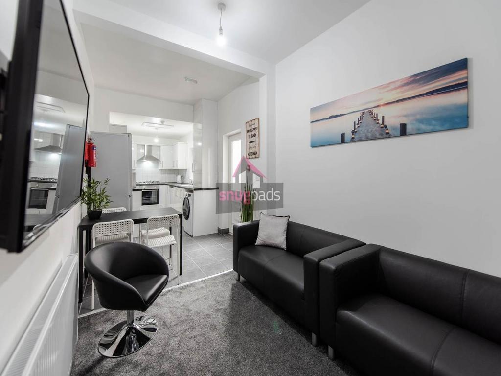 Modern open-plan living area with sleek black s...