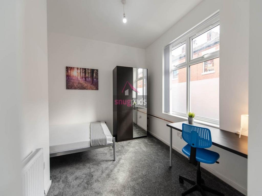 Bright, neutrally decorated bedroom with a sing...