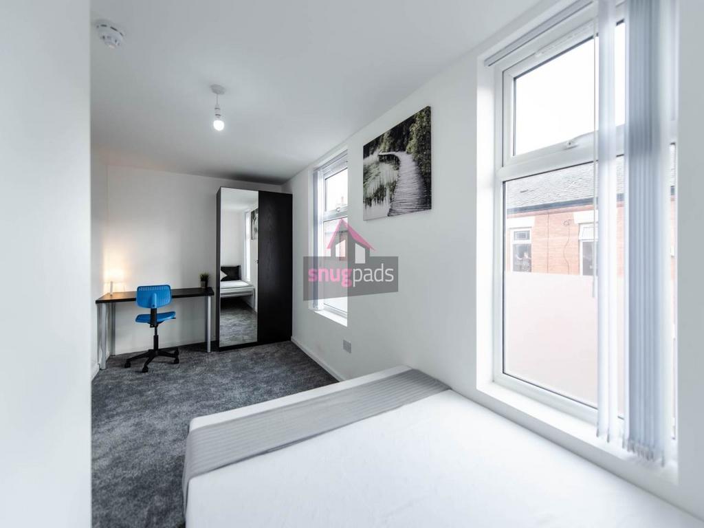 Bright, simply furnished bedroom with a large w...