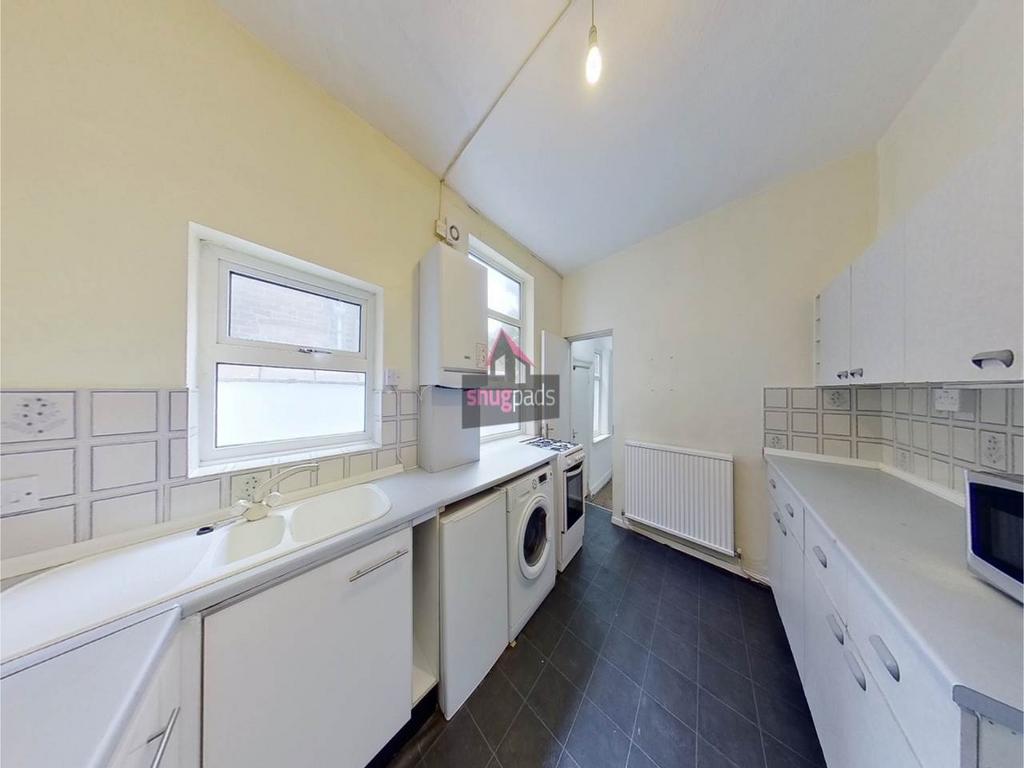 Bright, well-maintained galley kitchen with whi...