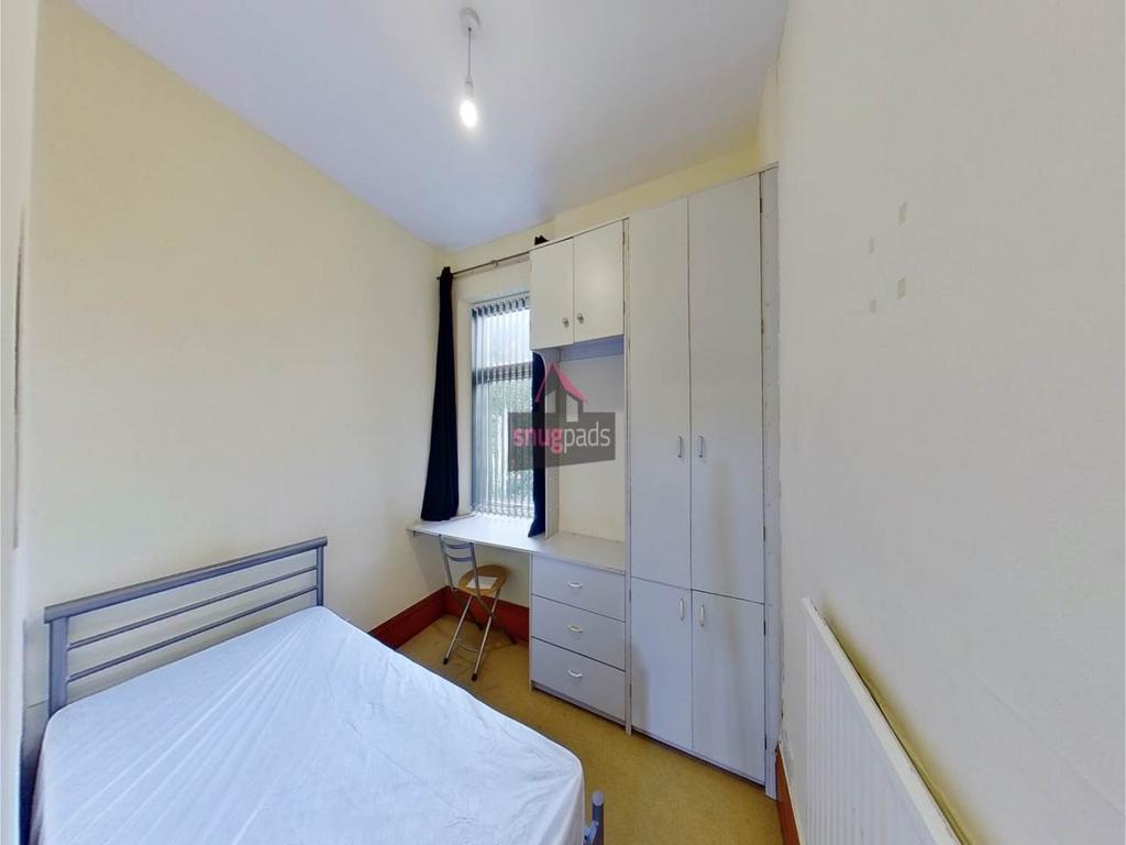 Bright bedroom with a double bed, fitted wardro...