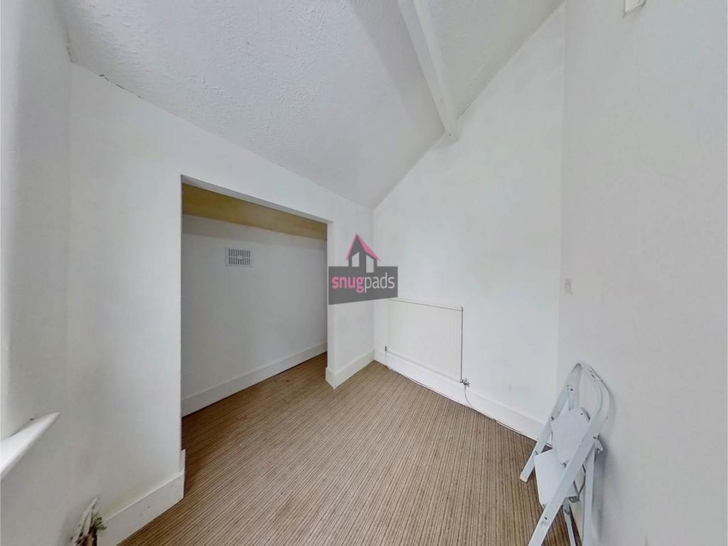 Bright, neutrally decorated room with high vaul...