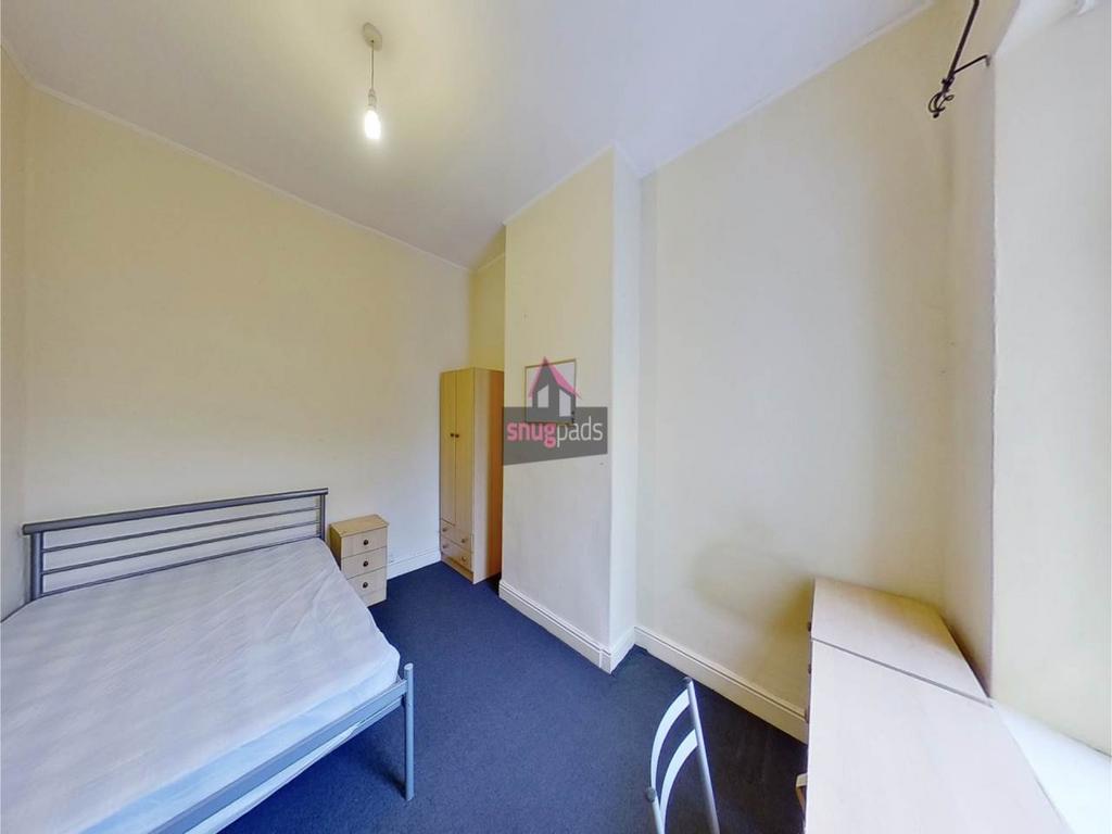 Bright furnished bedroom with a metal-frame bed...