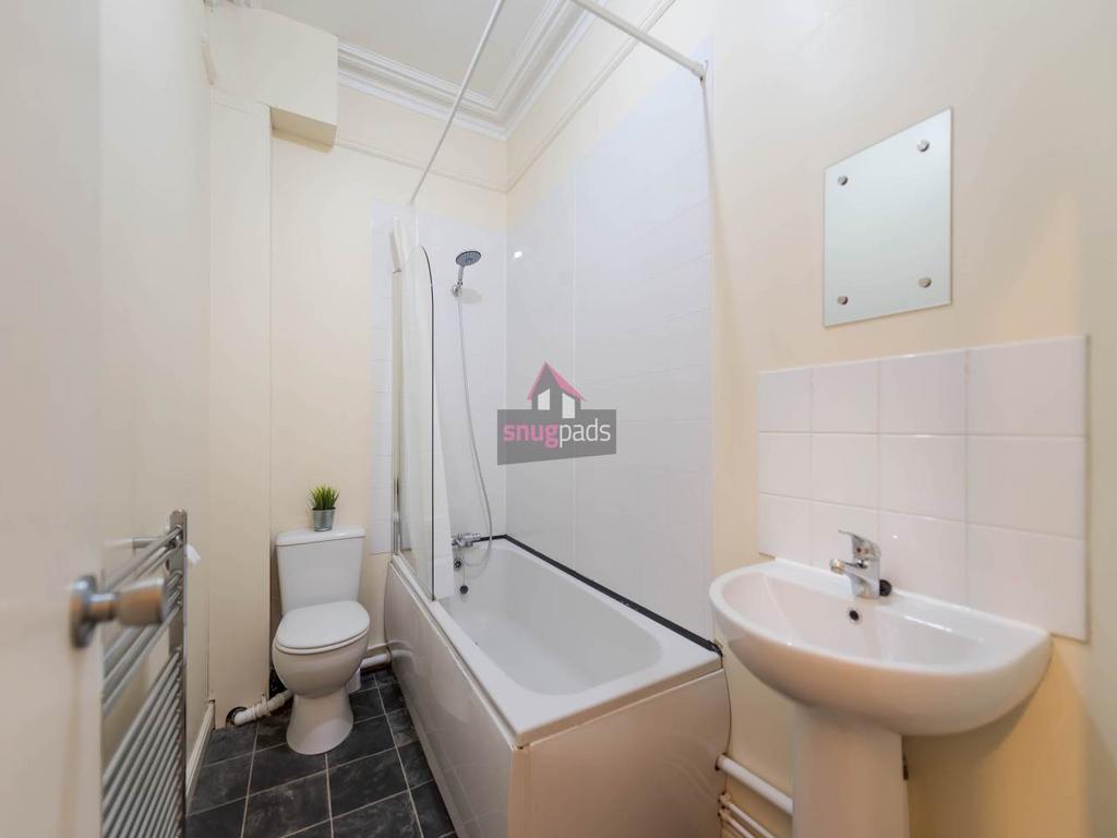 Bright, well-maintained bathroom with a bathtub...