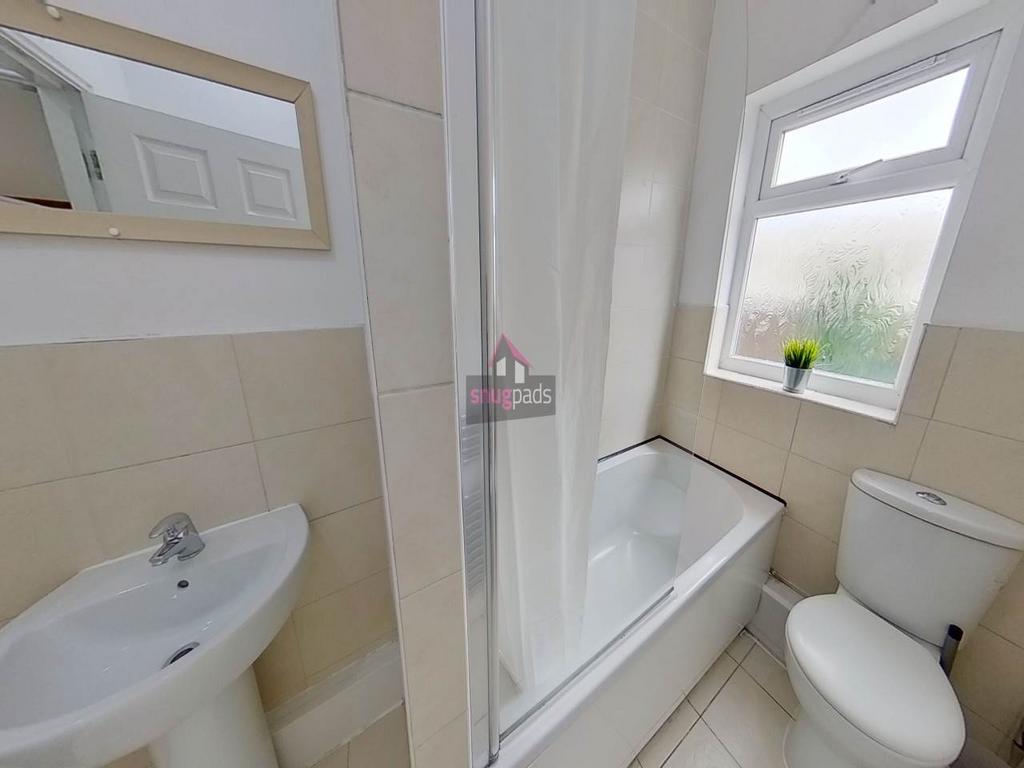 Bright, well-kept bathroom featuring a bath wit...