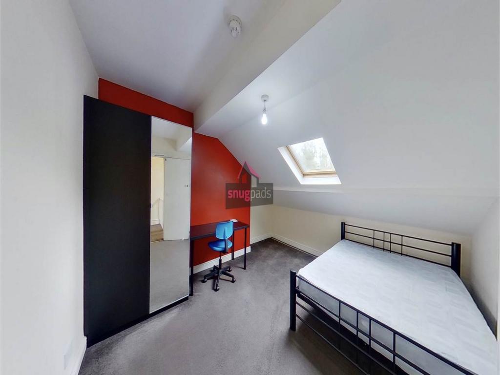 Bright attic bedroom with sloped ceiling and sk...