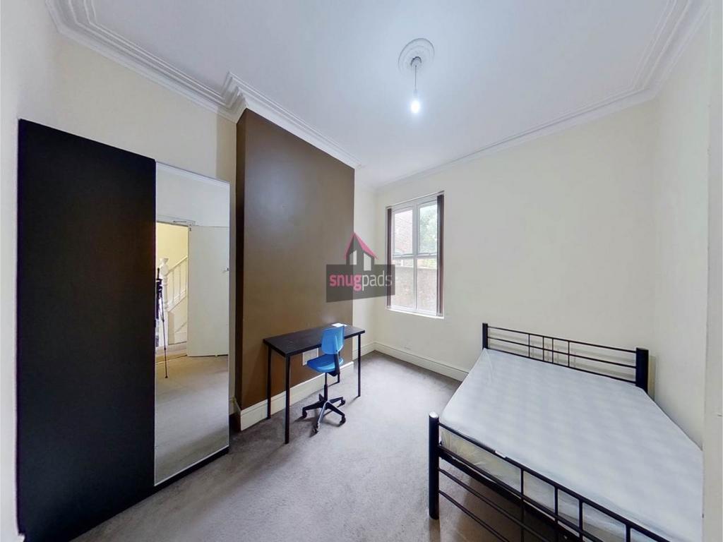 Bright, neutrally decorated bedroom with a meta...