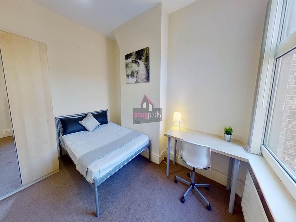 Bright, neatly furnished double bedroom with a ...