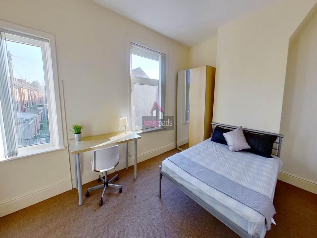 Bright, neatly presented bedroom with two tall ...