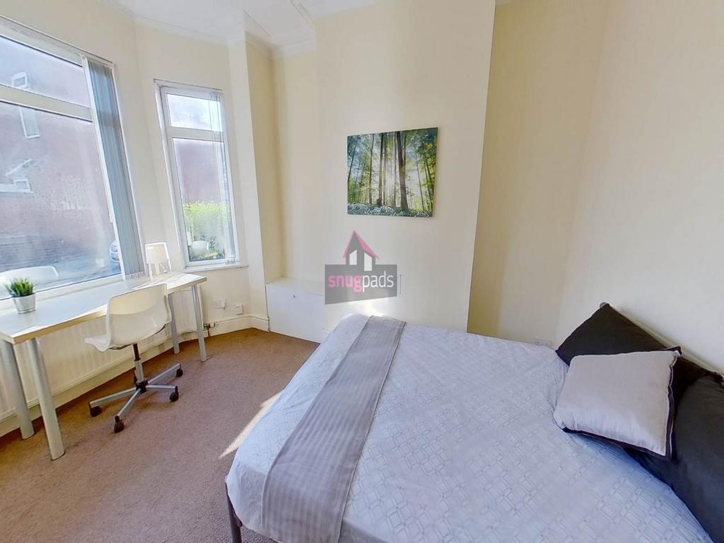 Bright, neat bedroom featuring a made double be...