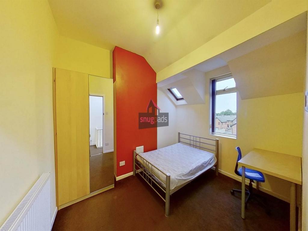 Bright, simply furnished bedroom with a double ...