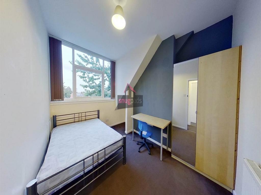 Bright, simply furnished bedroom with a large w...