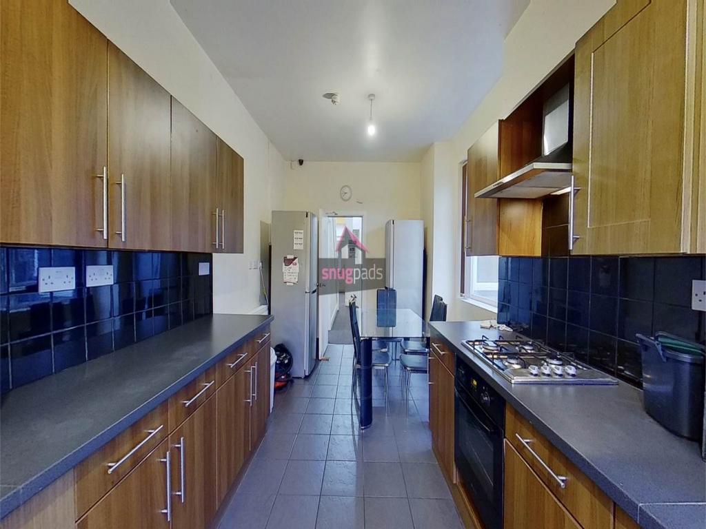 Bright galley kitchen with wooden cabinetry, da...