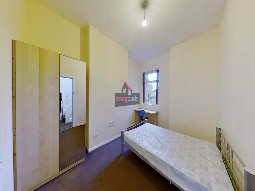 Bright, simply furnished bedroom with a single ...