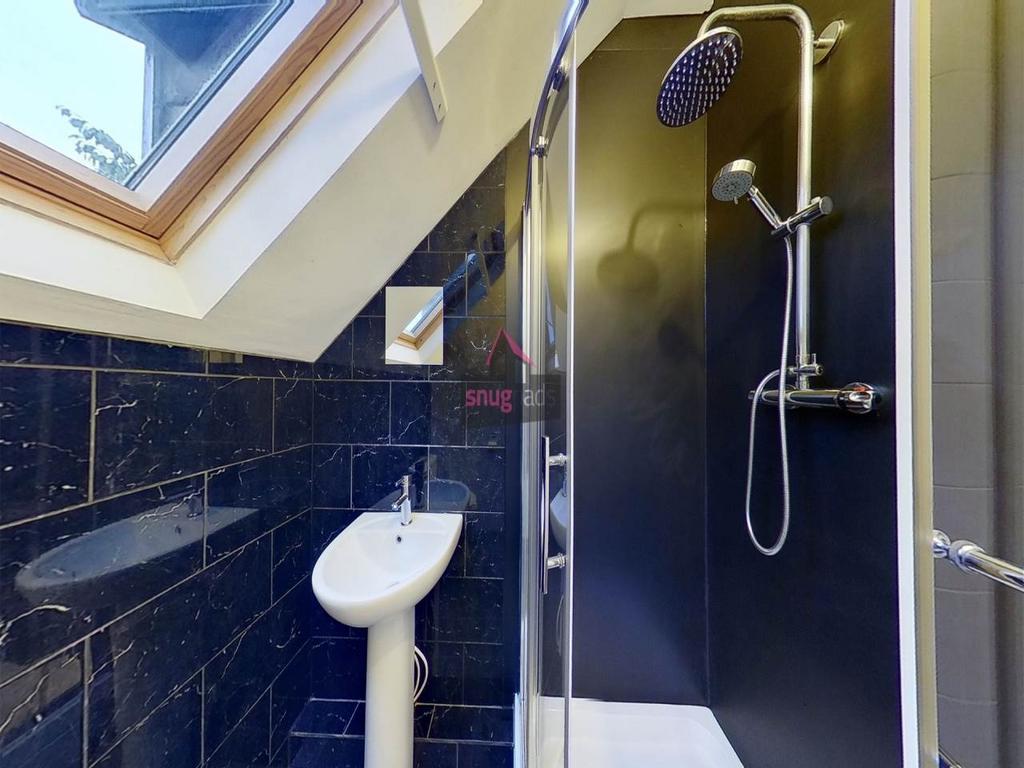 Bright angled bathroom with a skylight, modern ...