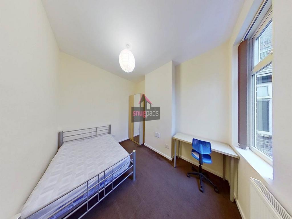 Bright furnished bedroom with a single bed, bui...