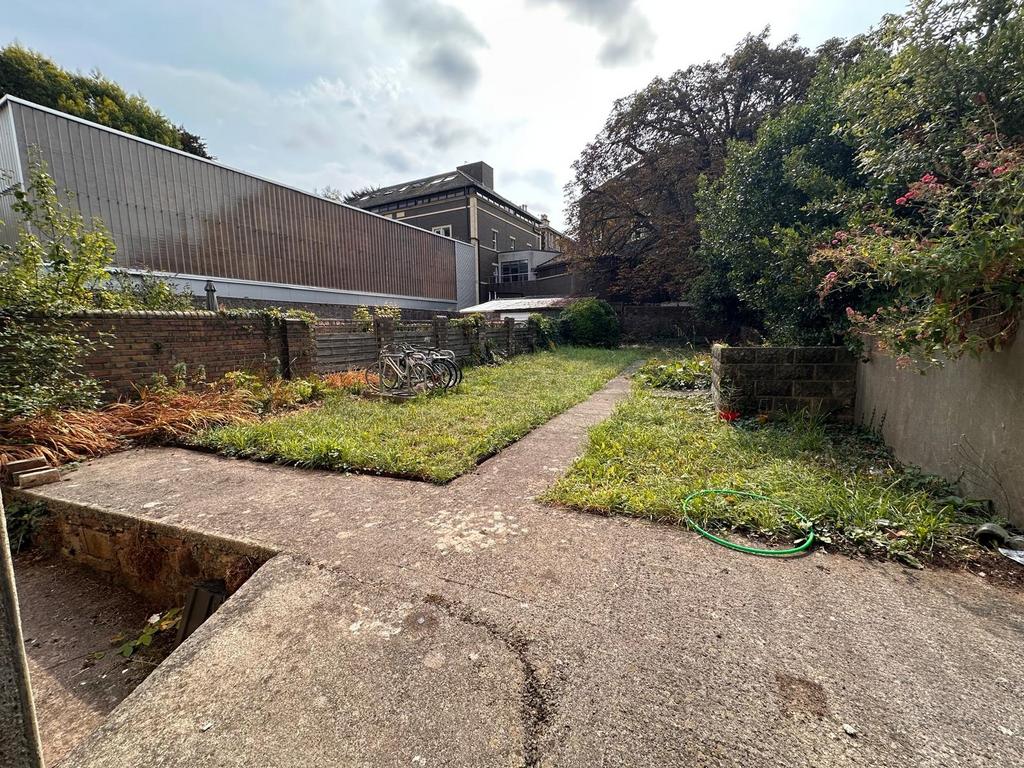 Private rear garden with a central paved path, ...