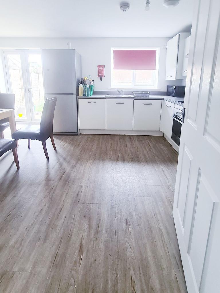 Bright modern kitchen with white cabinets, inte...