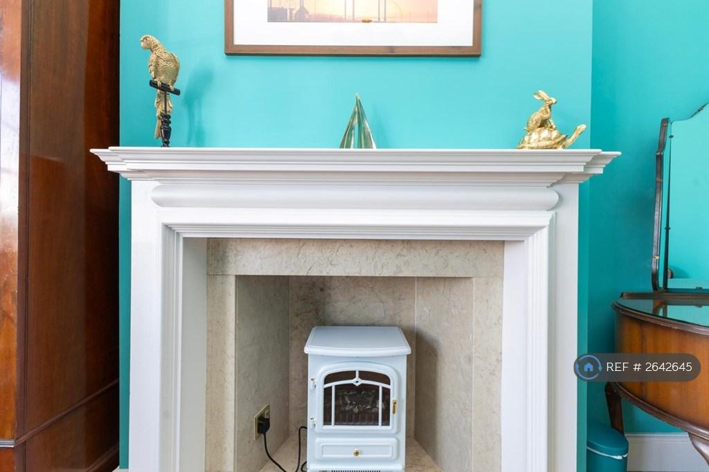 Feature Fireplace In Bedroom One.