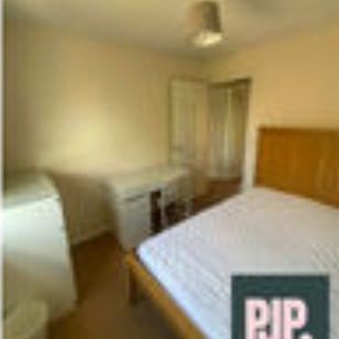 Bright, simply furnished bedroom with a double ...