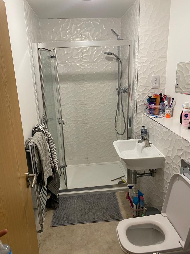 Bright, modern bathroom with patterned white wa...