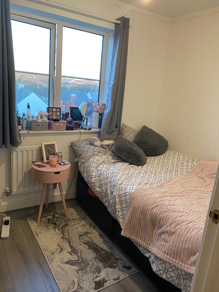 Bright, neatly styled bedroom with a large wind...