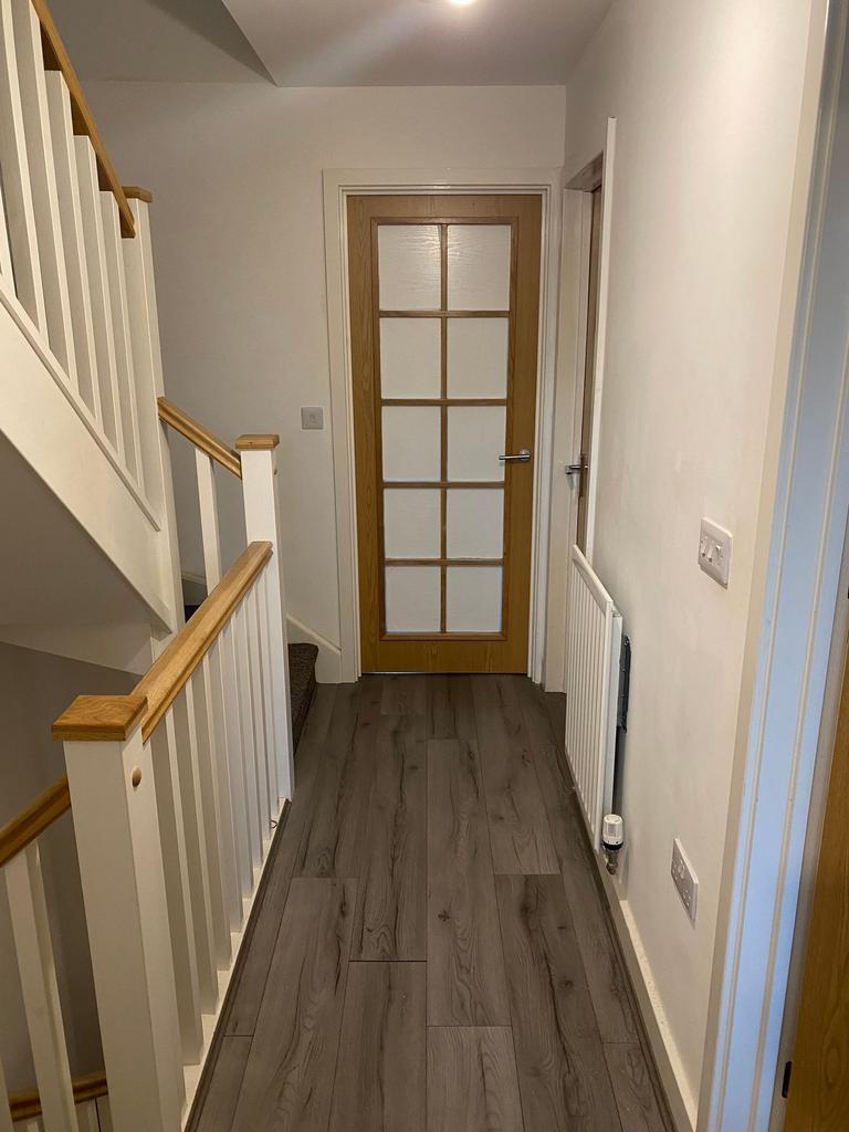 Bright, modern hallway with wood-effect floorin...