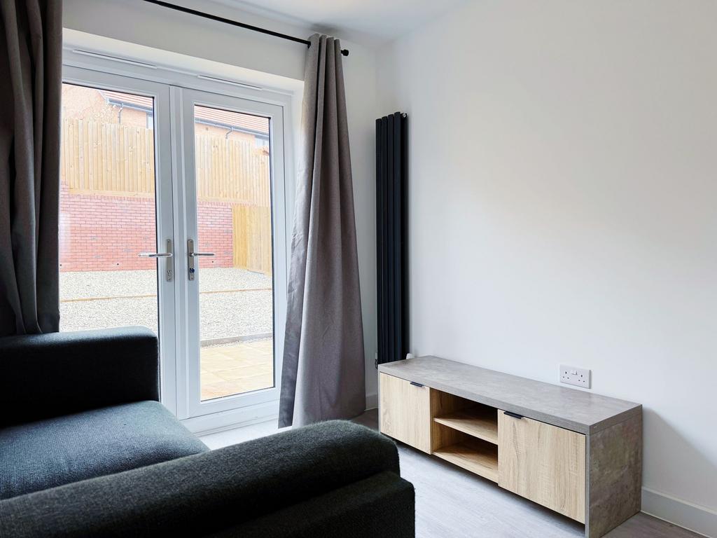 Bright, modern living area with full-height pat...