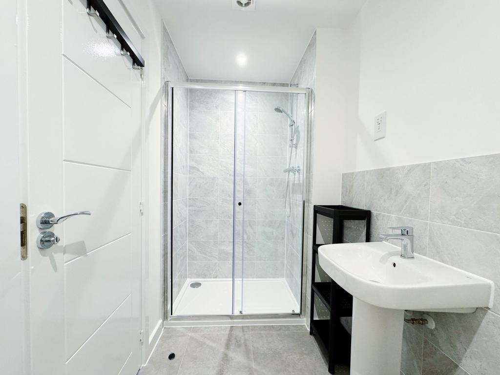 Bright, modern bathroom with a glass-enclosed w...