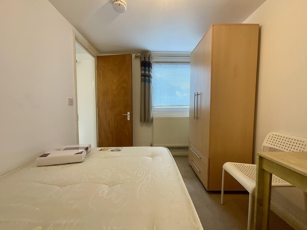 Neat, simply furnished bedroom with a comfortab...