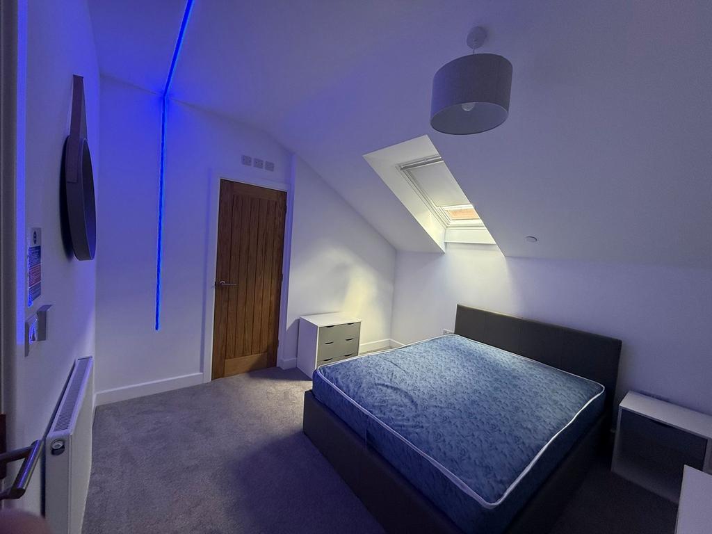 Bright attic master bedroom with a large double...