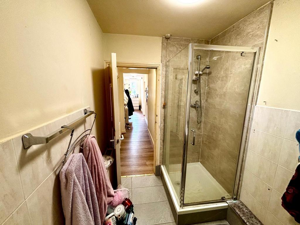 A functional bathroom featuring a shower with a...