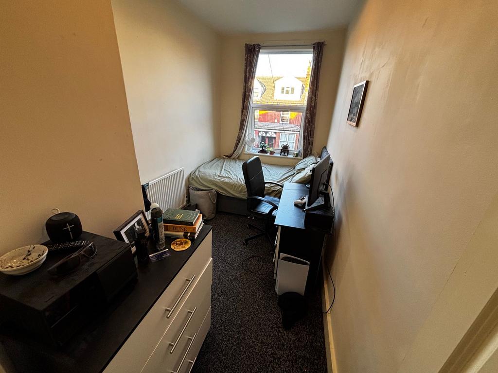 Bright, neatly kept bedroom with a window at th...