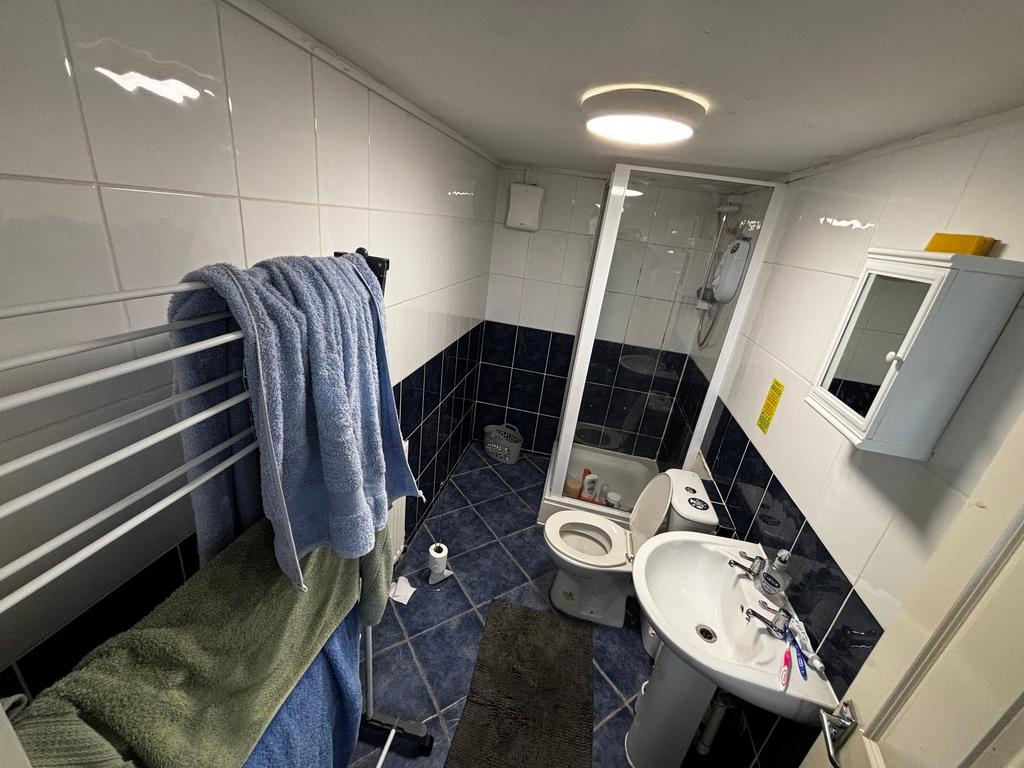 Tiled bathroom with a corner shower cubicle, pe...