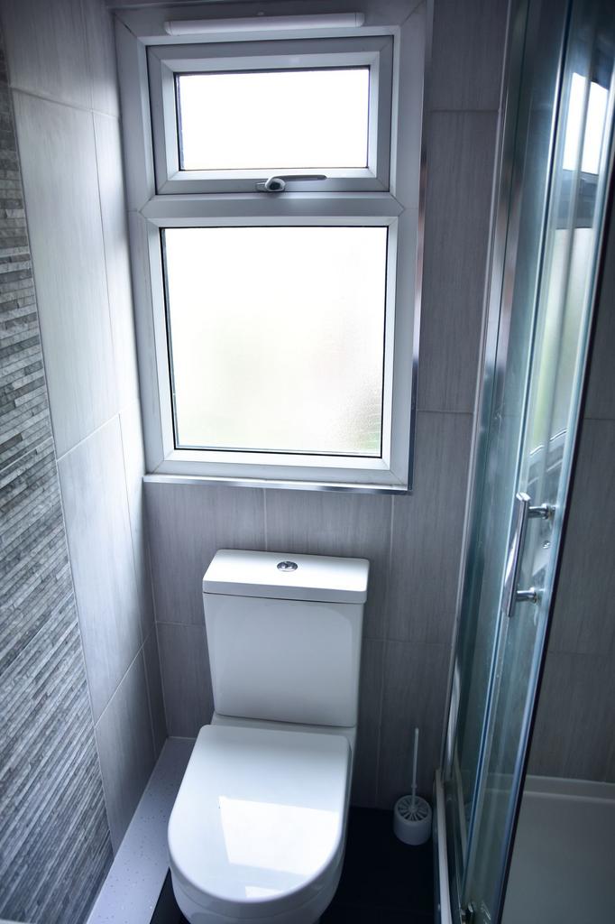 A modern, clean bathroom featuring a white toil...